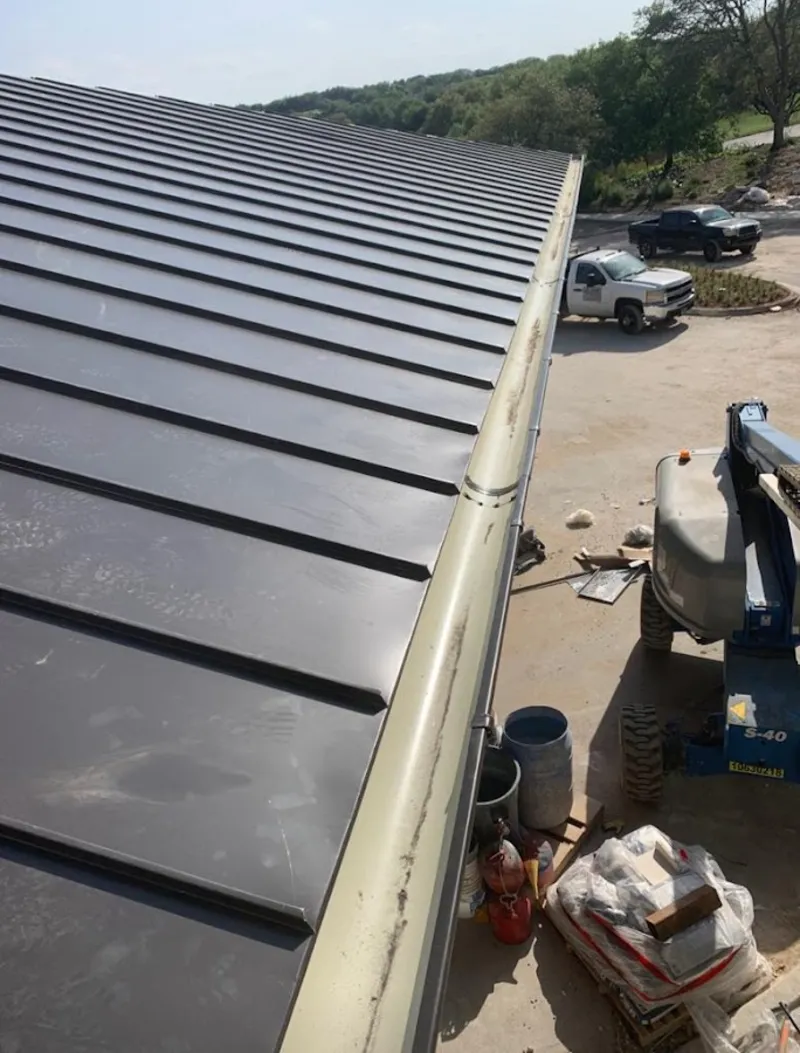 Standing seam panel and gutter detail on a metal roofing jobsite in Wellington